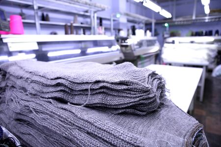 Pink spools of thread on the background of the sewing workshop. Clothing industry. Machine for the...