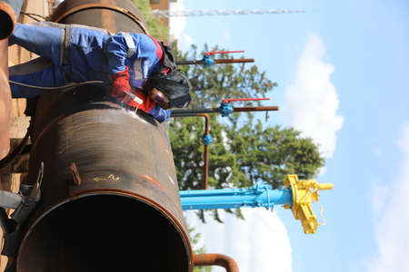 Male welder works. Welding joint of large diameter pipe. High pressure pipe welding for a gas...