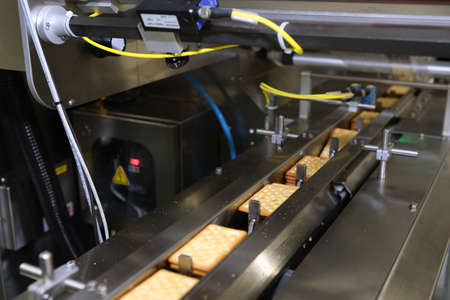 A lot of cookies on the production line. The flow of sweets before packaging. Packing crackers on...