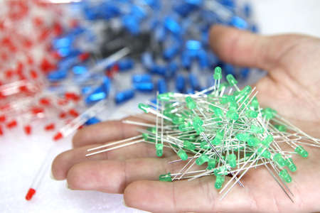 Lots of radios. Loose electronic parts on the table. Digital indicator, LEDs, capacitor and microcircuits in a pile.の写真素材