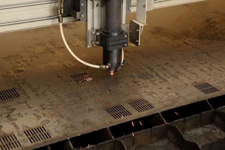 Plasma cutting CNC machine cuts metal material with sparks, industry background aerospace. Robotic plasma cutting machine. Plasma hole cutting programming..の写真素材