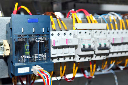 Electrician engineer work tester measuring voltage and current of power electric line in electical cabinet control.and wires on relay protection system. Bay control unit. Medium voltage switchgear..の写真素材