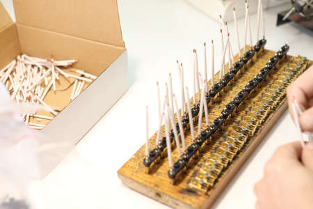 A man collects a printed circuit board. The worker solders the radio components and assembles the...