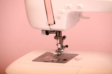 Composition from a sewing machine. Mannequin, flowers on a retro table and threads. Sewing supplies and composition with a sewing machine in the interior. With the letter M. The composition is unique for the fashion.の写真素材