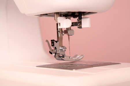 Composition from a sewing machine. Mannequin, flowers on a retro table and threads. Sewing supplies...