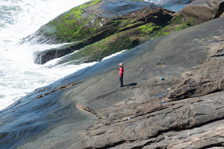 Mountains, vegetation and the ocean with clear blue waters of Praia de Grumari, located in the city...