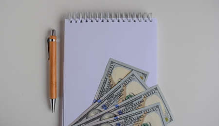 Notebook for notes with hundred dollar bills and penの写真素材