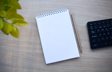 A blank notebook with pencil on wood desk background. Top view with copy space.の写真素材