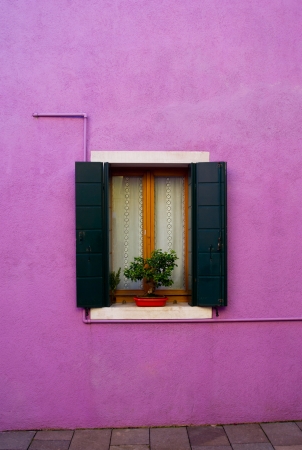 open window with wooden shutters in a purple wallの写真素材