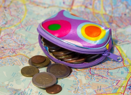 purse, and a handful of coins from different countries on a mapの写真素材