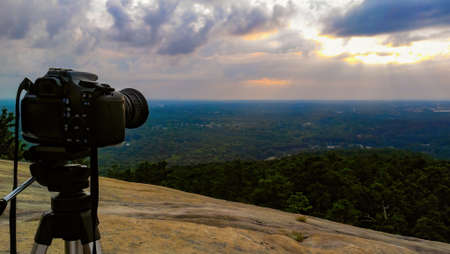 Camera on tripod overlooking sunrise on a cloudy morningの写真素材