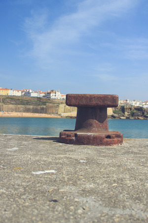 Old rusty steel mooring bollard pole on a pierの写真素材