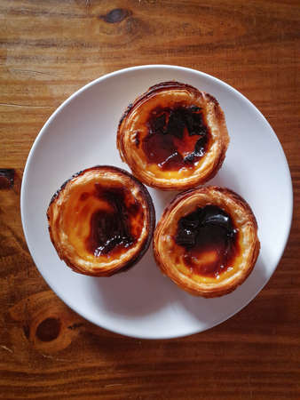 Pastel de nata, traditional Portuguese egg tart on wooden backgroundの写真素材