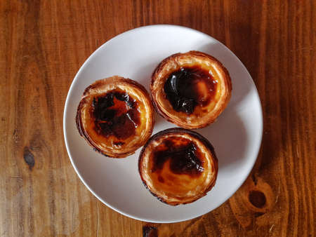 Egg tart, traditional portuguese dessert on a wooden tableの写真素材