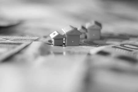 House model and dollar banknotes. Real estate concept. Black and white photo.