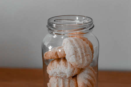 glass Jar with homemade cookies on light background