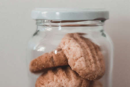 glass Jar with homemade cookies on light background