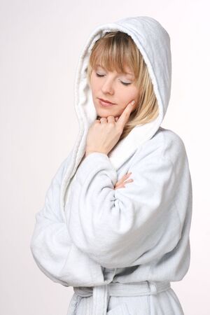 Beautiful Blonde Woman In Hooded White Bathrobe Thinkingの写真素材