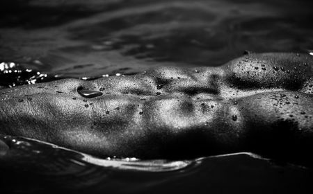 Closeup Monotone  Photo Of A Muscular Male Abdomen And Pecs Shining On Waterの写真素材