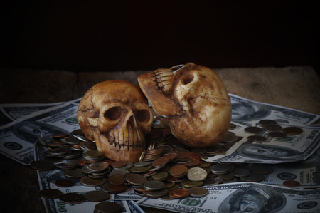 skull on bank note and coin, money, concept in work for money and death because of money