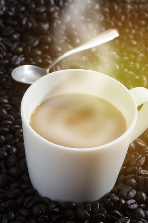 cup of coffee on seed of coffee with smokeの写真素材