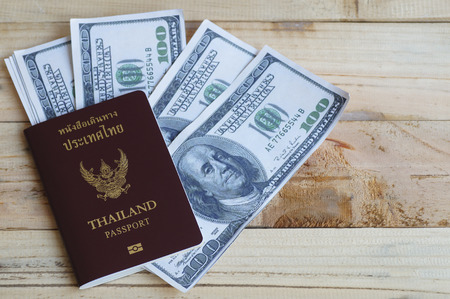 100 dollars with passport on wood backgroundの写真素材