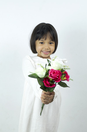 cute young girl holding flower on soft white backgroundの写真素材