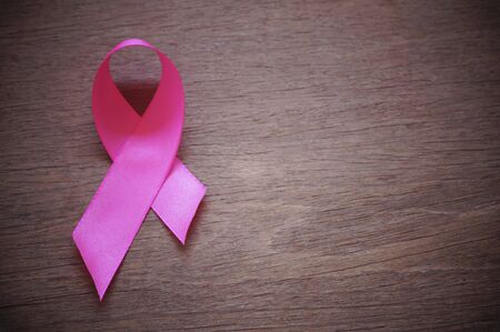 pink ribbon breast cancer on wood background with copy spaceの写真素材