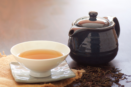 green tea in cup and pot on wood tableの写真素材