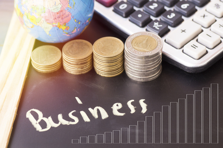 Business word of chalk on blackboard,pile coin money with account book finance and banking concept for background, concept in grow and walk step by step for success in businessの写真素材