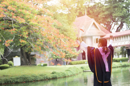 Happy and glad graduated Asian student girl standing and showing hand, congratulations, graduate education success, concept education and finished learning in classの写真素材