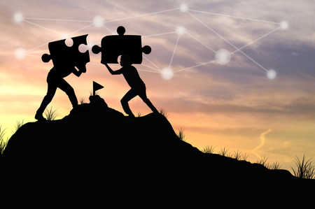 Silhouette people helping to connect jigsaw and puzzle to success, concept as improving and development businessの写真素材