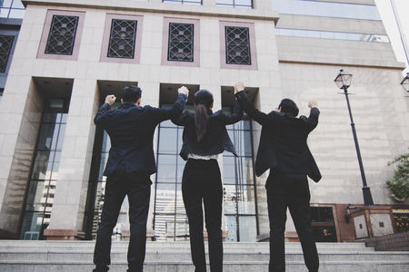 Hand coordination of team businessman on sky infront of bank building, office after successful projectの写真素材