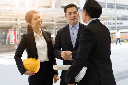 Engineering team shaking hand with busineeman, investor, boss outside after successful deal projectの写真素材