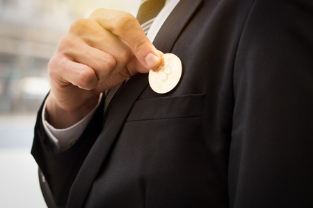 Investmen and business concept, businessman save money in pocket and investment, symbol of crypto currencyの写真素材