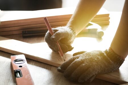 carpenter measuring and writing on wood with copy space backgroundの写真素材