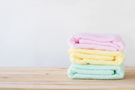 towel on wood table with white wall and copy space, can be used for present productsの写真素材