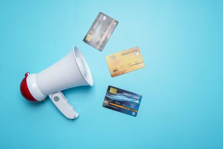 Megaphone with credit card on blue background, Cheap interest public relations conceptの写真素材