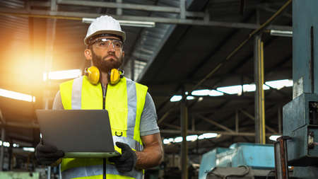 engineer working in handling hard in industrial machine, worker wearing white hard helmet control...