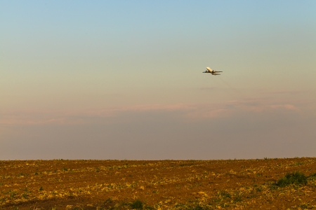 Aircraft takes off over the field の写真素材