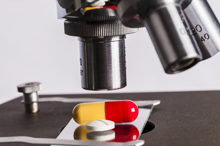 Science lab research safe of new drugs, microscope and pillsの写真素材