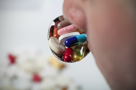 mouth with spoon full of pills