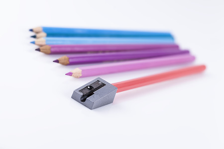 Colored pencils with sharpener on white backgroundの写真素材