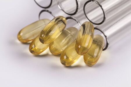 Small pile of nutritional vitamins with pills and test tube