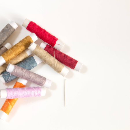 Colored sewing threads on a white tableの写真素材