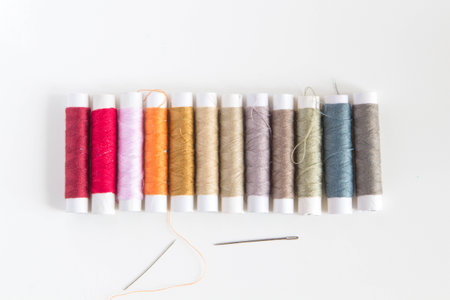 Colored sewing threads on a white tableの写真素材