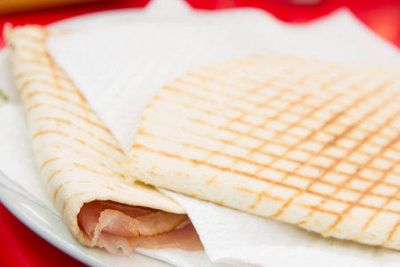 Close up of italian piadina with ham and fresh saladの写真素材
