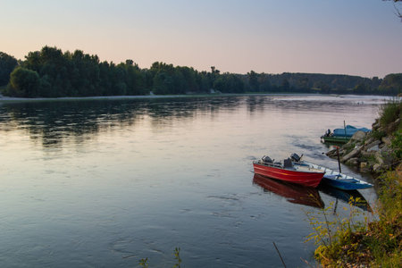 small rusty boats on Ticino River at sunset, Italyの写真素材