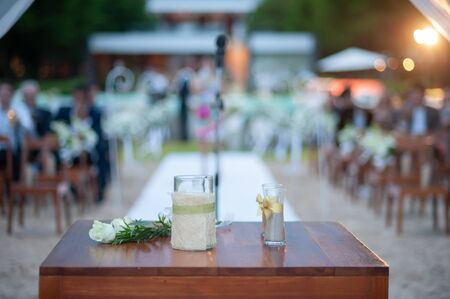 Wedding decorations such as flowers and glass placed on a brown wooden table With background blurの写真素材