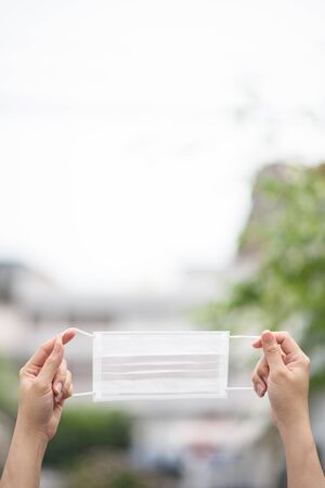 The hand holding the mask during the period of PM2.5 and coronavirus, covid 19の写真素材